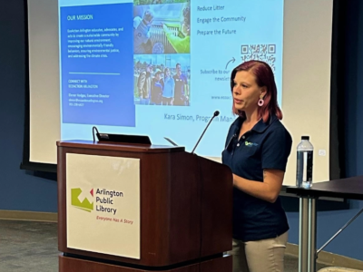 Kara Simon, EcoAction Arllingotn program manager speaks from behind the podium with a screen projected behind her.