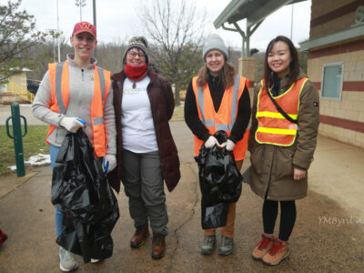 photo: four volunteers in coats and hats wearing orange vests smiling for the camera at Barcroft Park. photo credit: YMByrd Art.