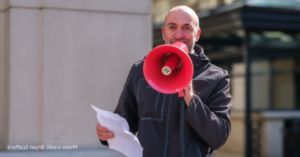 close up of Mike Lowe, EcoAction Arlington Board Chair, speaking into a red megaphone. Photo credit: Bryan Scafford.