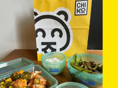 ChiKo takeout bag surrounded by green reusable take out containers filled with food