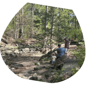 family of volunteers picking out trash from Four Mile Run