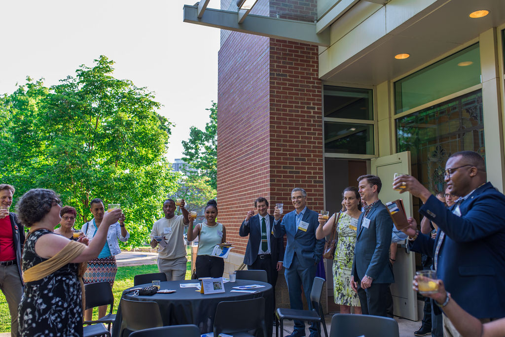 group of attendees in cocktail attire raising their glasses on the side patio of Arlington Center for the Arts